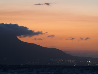 city at the foot of the mountain on the ocean. Dominican Republic. Beautiful orange sunset.