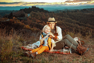 mother and child showing heart shaped hands while sitting on bla