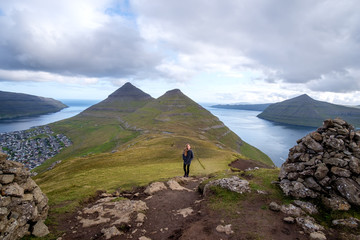 Young woman hiking near the town of Klaksvik, Bordoy, Faroe Islands