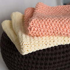 Photo of folded knitted blankets in a pile; handmade; knitting