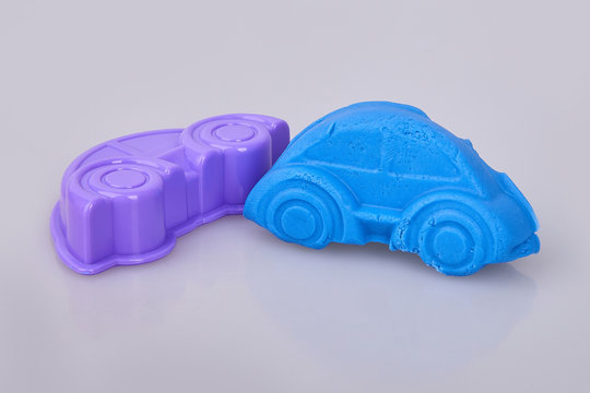 A car formed  from blue play dough (plasticine). Modeling. Play dough in preschool or nursery for education concept.  Materials and tools for modeling. Kids plays with clay molding shapes