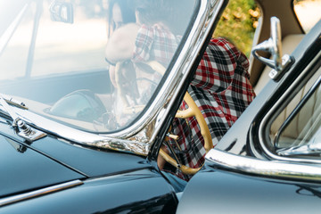 the man is sitting at the wheel, the driver. view from the rear window. Rear view of tourist guy in car. Travel and summer vacation concepts.