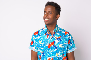 Happy young African tourist man with Afro hair thinking