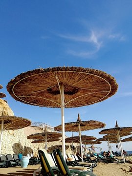 Beach Straw Umbrella Against The Sky. Outdoor