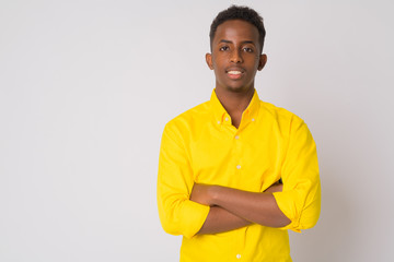 Happy young African businessman smiling with arms crossed