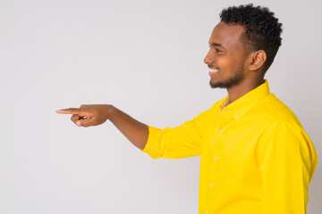 Profile view of happy young African businessman pointing finger