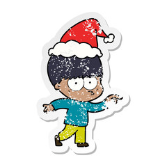 nervous distressed sticker cartoon of a boy wearing santa hat