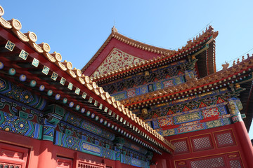 Fototapeta na wymiar Tiled roof and facade decorated with a Chinese pattern. Palace in The Forbidden City, Beijing, China