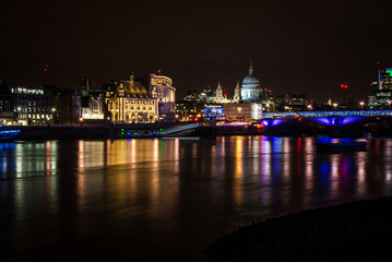 Fototapeta na wymiar London's skyline and Thames river at night