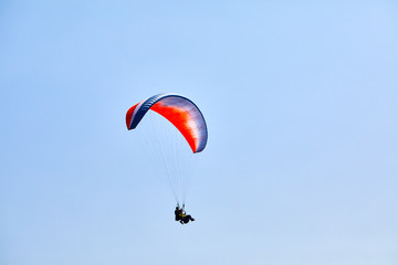 Flying on a paraglider. Beautiful view with mountains and colorful paragliders. Extreme vacation travel