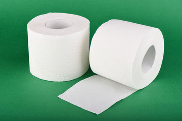 Two rolls of toilet paper isolated on green background