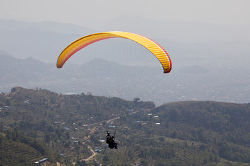 Flying on a paraglider. Beautiful view with mountains and colorful paragliders. Extreme vacation...