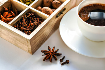 still life with black coffee in a white cup and a wooden box with spices