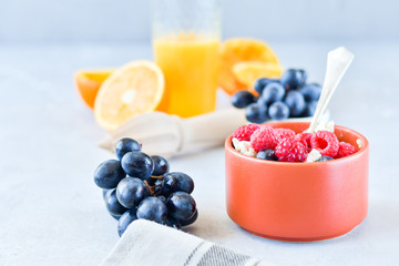 oatmeal with organic blueberries and raspberries, fresh orange juice and grapes. light background, selective focus and copy space, Breakfast concept. diet, healthy food