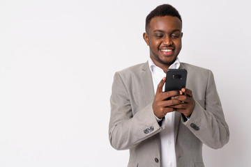 Portrait of happy young African businessman using phone