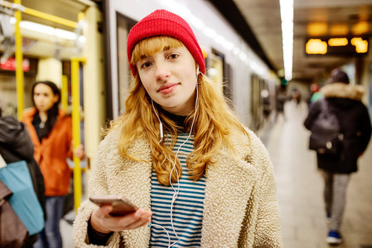 junge Frau wartet in einer U-Bahn Station auf den Zug