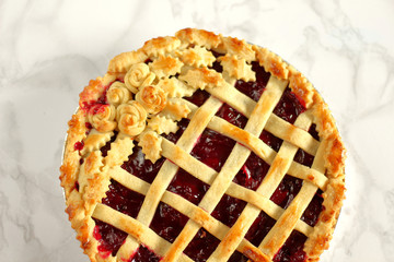 Classic old style homemade american cherry pie with a lattice on top decorated with rosettes and...