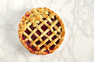 Classic old style homemade american cherry pie with a lattice on top decorated with rosettes and...