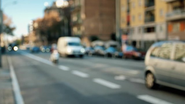 A busy street of a city, with cars slowly moving. Ext. Day, angled context blurred shot.