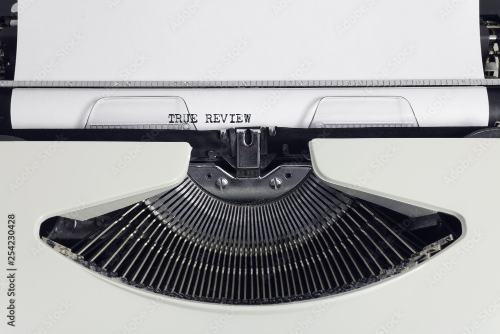 Poster old retro obsolete white typewriter with close-up typing text true review as heading on paper