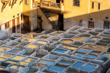 FES, MOROCCO - NOVEMBER 15, 2018:  Dye reservoirs in tannery in ancient medina Fes, Morocco, where the world famous moroccan leather is being made. Colored dye reservoirs and vats in a traditional tan