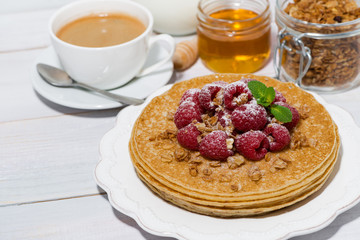 traditional thin pancakes with fresh raspberries for breakfast on wooden table, top view
