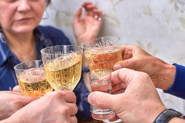 Champagne glasses and a shot of vodka in the hands of the guests, choking alcohol