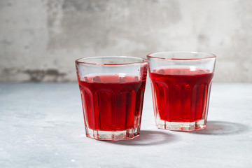 two glasses of red young wine on a gray background