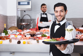 Waiter with serving tray in fish restaurant