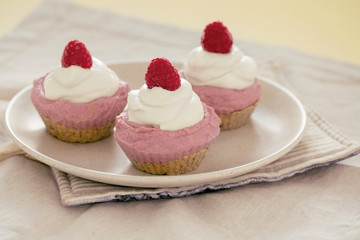homemade cake with raw strawberries and cashew cream on almond nut dough, healthy vegan food concept. close up