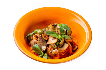 Plate of italian mushrooms pasta with olives, basil and broccoli isolated at white background.