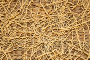 Natural background of woven plant based basket with curly pieces of weaving material