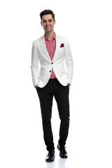 young successful young man standing with hands in pockets