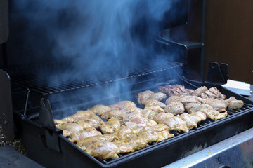 Sizzling, delicious grilled steak and chicken hot off the barbecue at an outdoor garden party