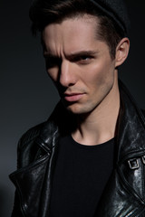 Fototapeta premium portrait of a dramatic man wearing leather jacket and hat
