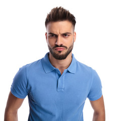 Obraz premium Young imature man wearing a light blue polo frowning