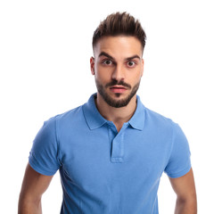 Fototapeta premium Casually-dressed youngster wearing a light blue polo being surprised