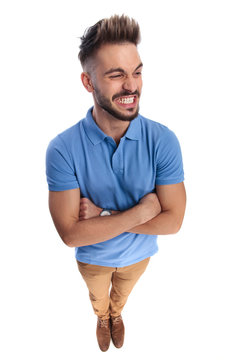 Young  casually-dressed man wearing a light blue polo looking at a side
