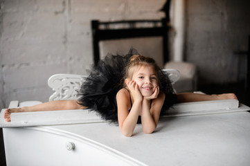 Little girl gymnast, performs various gymnastic and fitness exercises.
