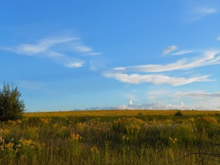 landscape with field and blue sky with inerest clouds.