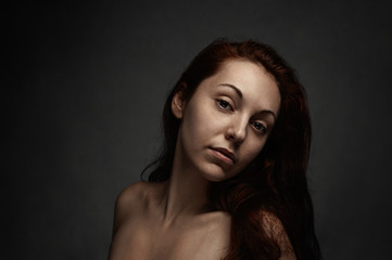 Portrait of beautiful nude lady on a black background.