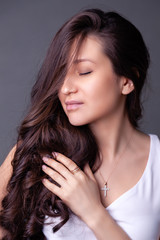 Fototapeta premium Closeup beautiful brunette girl with long hair in silver jewelry earrings, rings, bracelet, chain, necklace. Сoncept shooting jewelry store gentle, elegant, delicate, romantic bijouterie on model