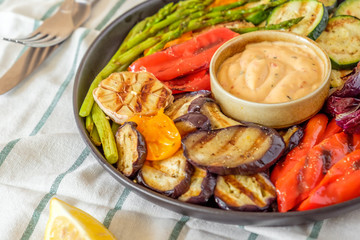 Grilled vegetables on a plate with sauce