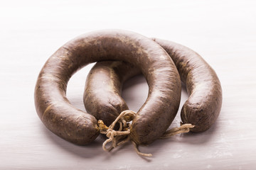 Food, meat and delicious concept - sliced horse meat sausage with cumin