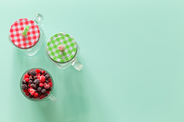 A healthy cocktail of forest fruits on a background of pastel green glass top, Empty space for an inscription