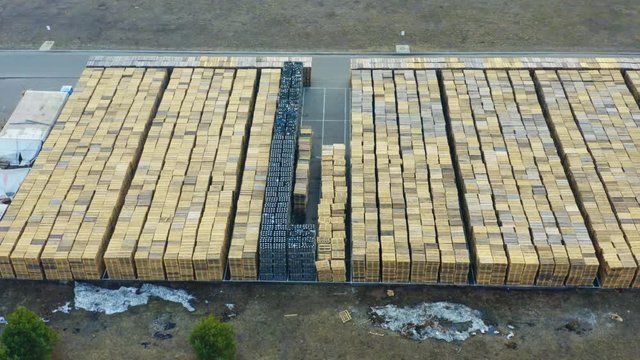 Aerial side view of the outside storage of wooden pallets on the logistics park territory
