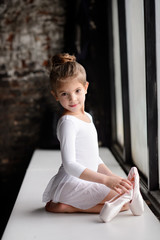 Beautiful girl in white dress posing indoor