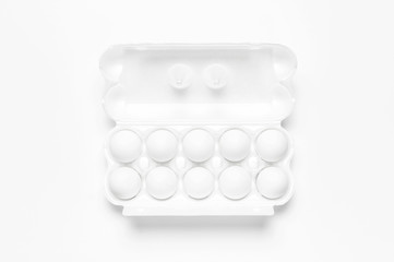White chicken eggs in white packaging on light background top view flat lay copy space. Eggs in box, natural healthy food and organic farming concept. Creative food minimalistic background, Easter