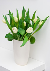 Fresh tulips on a white shelf home decoration