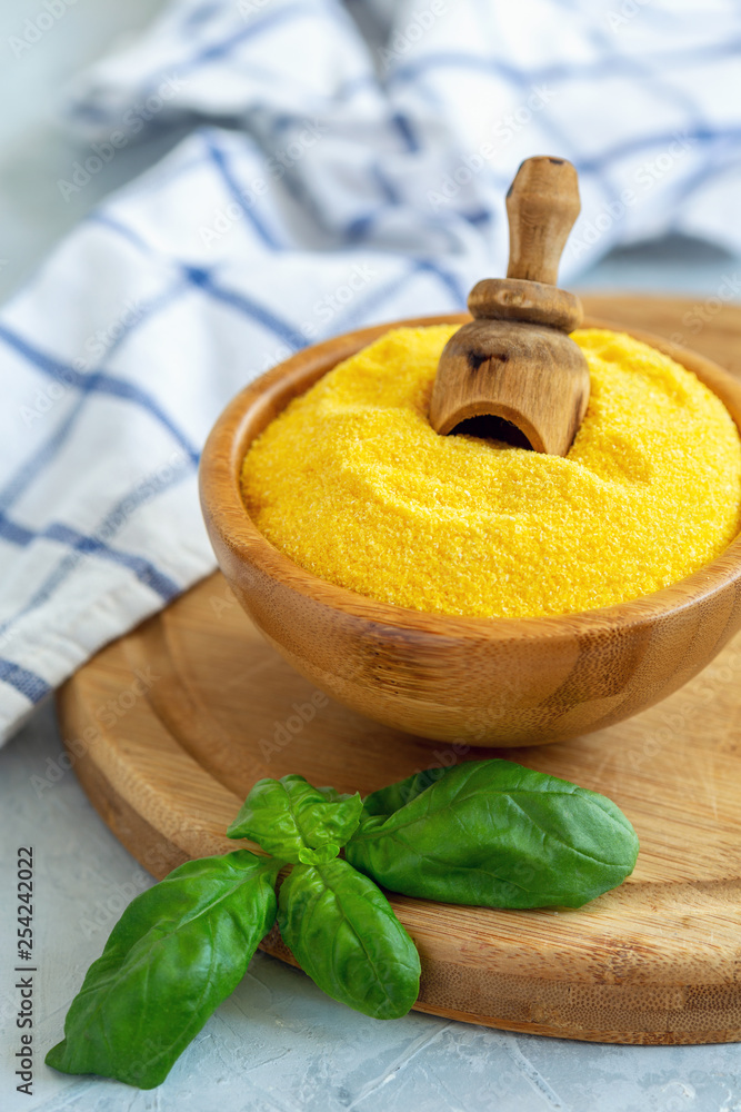 Wall mural traditional uncooked italian polenta in a wooden bowl.